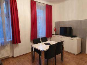 une salle à manger avec des rideaux rouges et une table avec des chaises dans l'établissement Vibrant Red Apartment I contactless Check-In, à Vienne