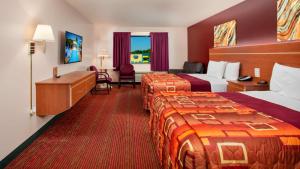 a hotel room with two beds and a desk at Grand Marquis Waterpark Hotel & Suites in Wisconsin Dells