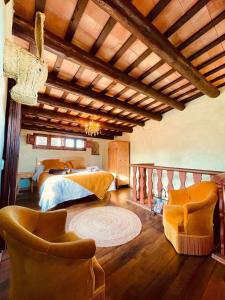 a bedroom with a bed and two chairs at Casa de campo del S.XVII in Cruïlles