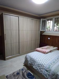 a bedroom with a bed and a large cabinet at Appartamento vicino alle piramidi in Cairo