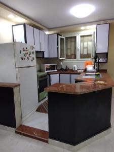 a kitchen with white cabinets and a white refrigerator at Appartamento vicino alle piramidi in Cairo