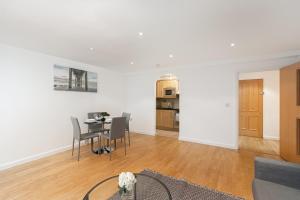 uma sala de estar branca com uma mesa e cadeiras em Skyvillion - Station Road Apartment with Balcony & Parking em New Barnet