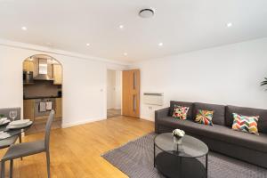 Skyvillion - Station Road Apartment with Balcony & Parking في New Barnet: غرفة معيشة مع أريكة وطاولة