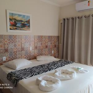 a bedroom with two beds with towels on them at Raízes Hotel in Cajobi