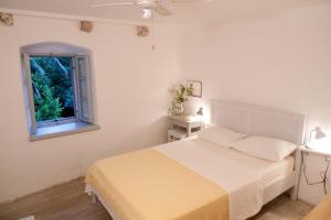 a white bedroom with a bed and a window at Holiday Home Misir in Bol