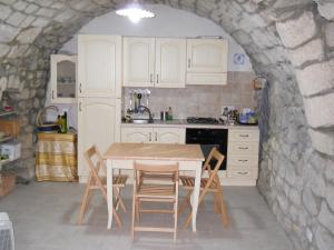 una cucina con tavolo e sedie in un muro di pietra di Casa vacanze Fuori Tema a Ragusa