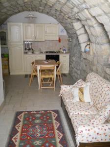 een woonkamer met een bank en een tafel in een keuken bij Casa vacanze Fuori Tema in Ragusa