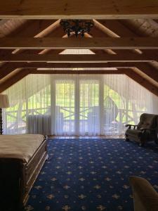 a bedroom with a bed and a large window at Sadyba Lisova in Ternopilʼ