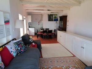 een woonkamer met een bank en een eetkamer bij Casa do Arcanjo in São Roque do Pico