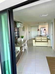a living room with a couch and a table at Tabatinga Residence Flat Pé na Areia II in Conde
