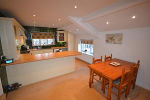 una cucina e una sala da pranzo con tavolo in legno di Eagle Cottage a Penrith