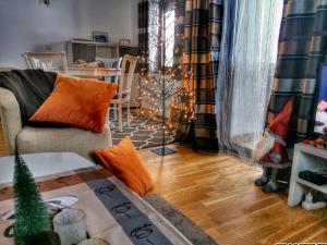 a living room with a christmas tree in the window at Vikendica Gradina Zlatibor in Čajetina