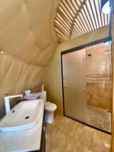 a bathroom with a white sink and a toilet at Kintiri Glamping in Nicoya