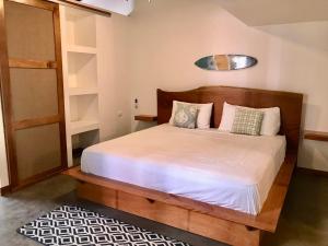 a bedroom with a bed with white sheets and pillows at La Buena Vida Cabinas in Playa Grande +14 photos