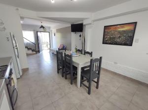 cocina y comedor con mesa y sillas en Los Nardos Duplex en San Salvador de Jujuy