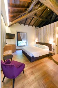 a bedroom with a large bed and a purple chair at Relais & Spa Castello di Casiglio in Erba +49 photos