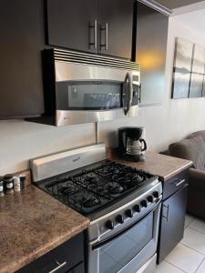 a kitchen with a stove and a microwave at Otay 2 bedroom condo in Tijuana