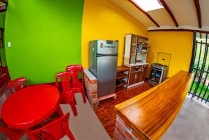 eine Küche mit einem Tisch, roten Stühlen und einem Kühlschrank in der Unterkunft Happy Land Valle Sagrado in Urubamba