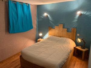 a bedroom with a large bed with a blue curtain at Appartement 6 pers - Les 4 Loups au pied des pistes in Gérardmer