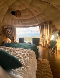 a bedroom with a bed and a large window at Kintiri Glamping in Nicoya