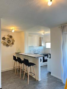 eine Küche mit einer Theke und Stühlen in einem Zimmer in der Unterkunft Superbe Studio en résidence proche de la Mer in Cagnes-sur-Mer