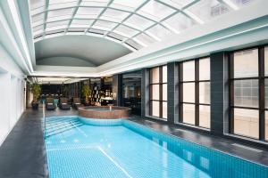 a swimming pool in a building with a glass ceiling at Stamford Plaza Melbourne in Melbourne