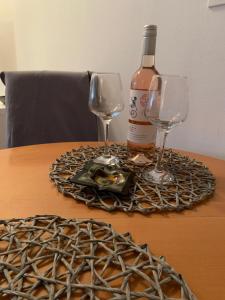 a bottle of wine and two wine glasses on a table at Šarmantni apartman Malecka 2 in Zagreb
