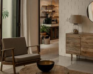 a living room with a chair and a dresser at Narrativ Lofts - Serena - Beautiful Colonial Suite in Campeche