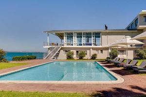 a house with a swimming pool in front of a house at Saldanha Bay Hotel in Saldanha