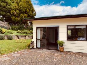 a small house with glass doors and a patio at Aranui Farmstay in Waitomo Caves