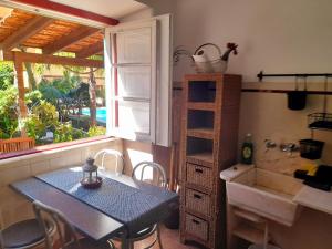 a dining room with a table and a sink and a window at Casa Mestre in Vila do Bispo