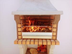 um forno de pizza com um fogo dentro dele em A Casa da Mila - Beach House em Costa da Caparica