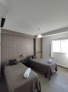 - une chambre avec 2 lits et une fenêtre dans l'établissement Los Nardos Duplex, à San Salvador de Jujuy