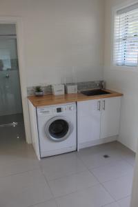 eine Küche mit einer Waschmaschine und einem Waschbecken in der Unterkunft Rosa's Apartment in Mount Gambier
