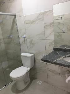 a bathroom with a toilet and a shower and a sink at Casa da Gina in Santa Cruz Cabrália