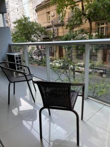 dwa krzesła siedzące na balkonie w obiekcie Departamento en el Centro de Recoleta con pileta, parrilla, gym y laundry w BuenosAires