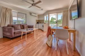 una sala de estar con una mesa y un sofá en Noosa Sun - On the Noosa River, en Noosaville