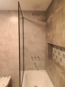 ein Badezimmer mit Dusche, Badewanne und Waschbecken in der Unterkunft El Descanso in Villa Giardino