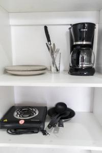a kitchen shelf with a stove and a coffee maker at NAPPO Room 2 Alajuela, Heredia,SJO,5min from airport NO PARKING in Guácima