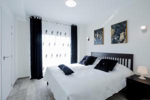 a bedroom with a white bed with black pillows at Palm Mar de LUX A25 in Palm-mar +46 photos