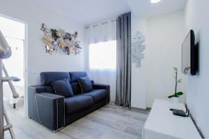 a living room with a blue couch and a tv at Palm Mar de LUX A25 in Palm-mar