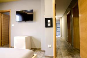 a bedroom with a bed and a television on a wall at Apartments "Our Place" Sarajevo in Ilidža