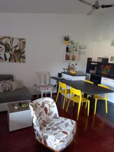 ein Wohnzimmer mit einem Tisch und gelben Stühlen in der Unterkunft APARTMAN SILVA in Biograd na Moru