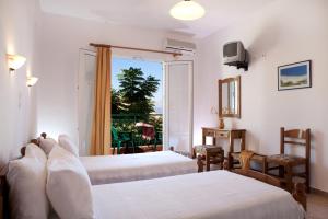 a hotel room with two beds and a balcony at Niriides in Nydri