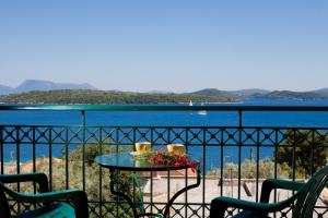 a table on a balcony with a view of the water at Niriides in Nydri