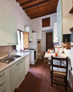 フィレンツェにあるApartments Florence - Via Pergola Mariaのキッチン(白いキャビネット、ダイニングルーム付きのテーブル付)