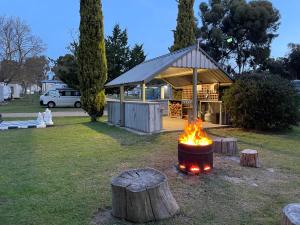 a fire pit in a yard with a building at Acacia Caravan Park & Holiday Units in Ararat
