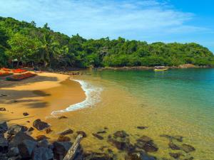 a sandy beach with a boat in the water at Villa Sunimal in Unawatuna