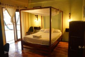 a bedroom with a canopy bed with towels on it at Sapa Inka in Montañita