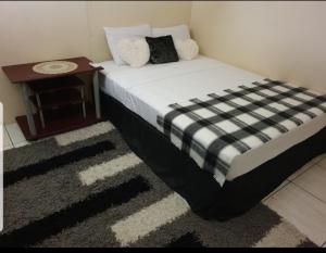 a bedroom with a bed with a nightstand and a bed sidx sidx at Signature comfort in Arima